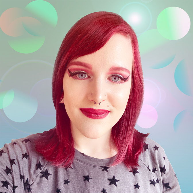headshot of Julie with subtle pastel colored overlapping spheres, suggestive of planets that complements the black and gray star shirt they are wearing