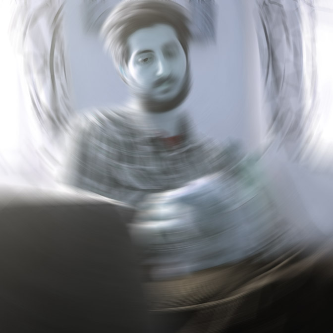 a blue grayish picture of a man sitting in what could be a living room, he's looking down, the entire image is blurred in a circular motion with his head being the center and only one eye being in focus