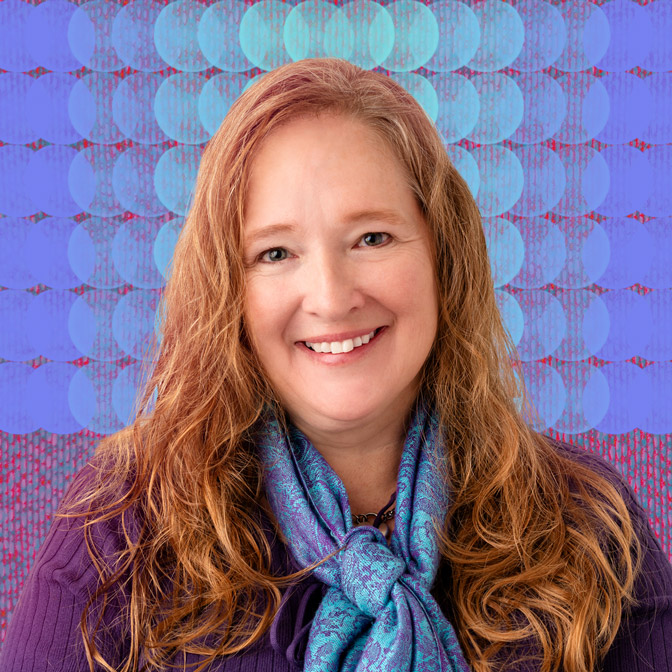Portrait of Kandace Carlin, LMHC, a licensed mental health counselor at Handel Behavioral Health in Amherst, Massachusetts, smiling against a blue patterned background.